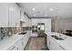 Spacious kitchen features white cabinetry, quartz countertops, stainless steel appliances, and tile flooring at 19891 Bridgetown Loop, Venice, FL 34293