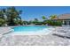 Community pool boasts ample lounge seating and a clear blue pool surrounded by lush greenery at 19891 Bridgetown Loop, Venice, FL 34293