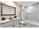 Bathroom features a white vanity with granite countertop, decorative framed mirror, tiled shower and tub with a white curtain at 3369 Houle Ave, Sarasota, FL 34232