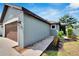 Modern single-story home featuring a walkway lined with rocks, lush bushes, and an attached two-car garage at 3369 Houle Ave, Sarasota, FL 34232
