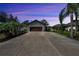 Charming single-story home with a long driveway, lush landscaping, and an attached two car garage at 3369 Houle Ave, Sarasota, FL 34232