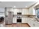 Well-lit kitchen featuring stainless steel appliances, white cabinetry, granite countertops, and modern finishes at 3369 Houle Ave, Sarasota, FL 34232