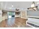 Open-concept living area with hardwood floors, stone accent wall, and sliding glass doors to the patio at 3369 Houle Ave, Sarasota, FL 34232