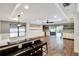 Open living room with hardwood floors, large windows, bar seating, and sliding glass doors to outdoor patio at 3369 Houle Ave, Sarasota, FL 34232