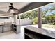 Outdoor kitchen with stone countertops, a built-in grill, and stainless steel cabinets at 3369 Houle Ave, Sarasota, FL 34232