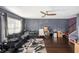 Spacious living room featuring hardwood floors, a ceiling fan, and large windows at 3875 Mariner Dr, St Petersburg, FL 33705