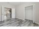 Bright bedroom featuring wood-look floors, a walk-in closet, and entry to the kitchen at 11321 Flora Springs Dr, Riverview, FL 33579