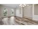 Dining room featuring new vinyl floors, chandelier, and two windows for natural light at 11321 Flora Springs Dr, Riverview, FL 33579