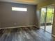 An open-concept living room features gray walls, new vinyl floors, and sliding glass doors to the patio at 11321 Flora Springs Dr, Riverview, FL 33579