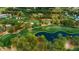 Aerial view of a golf course with water features, manicured greens, and surrounding lush trees at 36750 Us Highway 19 # 21-301, Palm Harbor, FL 34684