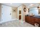 Bathroom vanity area with cabinets, decorative mirrors, granite countertop, vessel sink, and a nearby entrance at 36750 Us Highway 19 # 21-301, Palm Harbor, FL 34684