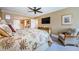 Inviting bedroom featuring a ceiling fan, TV, woven furniture, and a tropical-themed bedspread at 36750 Us Highway 19 # 21-301, Palm Harbor, FL 34684