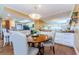 Bright dining area with round wood table, upholstered chairs, and mirrored wall open to the kitchen at 36750 Us Highway 19 # 21-301, Palm Harbor, FL 34684