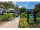 Condo building exterior showcasing mature landscaping and signage, creating a serene entrance at 36750 Us Highway 19 # 21-301, Palm Harbor, FL 34684