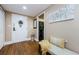 Inviting foyer with wood floors, a white door with floral decor, and a decorative bench at 36750 Us Highway 19 # 21-301, Palm Harbor, FL 34684