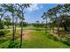 Expansive golf course view with rolling green fairways, trees, and a serene pond on a sunny day at 36750 Us Highway 19 # 21-301, Palm Harbor, FL 34684