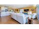Comfortable living room with a large sofa, wood floors, and seamless access to the kitchen and dining areas at 36750 Us Highway 19 # 21-301, Palm Harbor, FL 34684