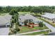 Aerial view of home, featuring a tile roof, manicured lawn, and golf course in the background at 394 Tall Oak Trl, Tarpon Springs, FL 34688