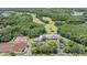 Aerial view of community clubhouse with tennis courts, surrounded by lush landscaping and green spaces at 394 Tall Oak Trl, Tarpon Springs, FL 34688