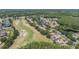 An aerial view of neighborhood, golf course, lakes, and trees at 394 Tall Oak Trl, Tarpon Springs, FL 34688