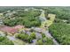 Aerial view of community clubhouse with tennis courts, surrounded by lush landscaping and green spaces at 394 Tall Oak Trl, Tarpon Springs, FL 34688