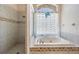 Bathroom featuring a shower and a tub with glass block window at 394 Tall Oak Trl, Tarpon Springs, FL 34688
