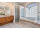 Bathroom featuring a vanity, shower, and tub with glass block window at 394 Tall Oak Trl, Tarpon Springs, FL 34688