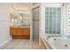 Bathroom featuring a vanity, shower, and tub with glass block window at 394 Tall Oak Trl, Tarpon Springs, FL 34688