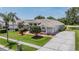 Charming one-story home with a tile roof, well-manicured lawn, and a concrete driveway at 394 Tall Oak Trl, Tarpon Springs, FL 34688