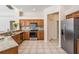 Well-lit kitchen featuring stainless steel appliances, tile floors, and natural wood cabinets at 394 Tall Oak Trl, Tarpon Springs, FL 34688