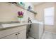 Well-equipped laundry room featuring a utility sink, ample counter space, and a modern washing machine at 394 Tall Oak Trl, Tarpon Springs, FL 34688