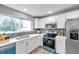 Bright kitchen features white cabinets, stainless steel appliances and subway tile backsplash at 6311 Newtown Cir # 11B1, Tampa, FL 33615
