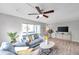 Comfortable living room features a ceiling fan, sliding glass doors, and an entertainment center at 6311 Newtown Cir # 11B1, Tampa, FL 33615