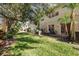 Spacious backyard with lush green grass, mature trees, and a charming patio area for outdoor enjoyment at 8907 Casablanca Way, Tampa, FL 33626