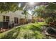 Lovely backyard featuring mature trees, a well-maintained lawn, and a cozy patio area at 8907 Casablanca Way, Tampa, FL 33626
