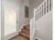 Stylish entry featuring a decorative glass door, wood-look flooring, and a staircase with white railings at 8907 Casablanca Way, Tampa, FL 33626
