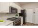 Updated kitchen with stainless steel microwave and electric range with white cabinetry at 8907 Casablanca Way, Tampa, FL 33626