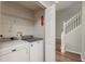 Laundry room featuring modern washer and dryer, wire shelves, and easy access to the stairs at 8907 Casablanca Way, Tampa, FL 33626