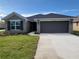 Inviting single-Gathering home featuring a well-kept lawn and a two-car garage at 13290 Ogden Glade Rd, Dade City, FL 33525