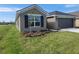 Front yard with lush grass and a flower bed featuring a small tree at 13290 Ogden Glade Rd, Dade City, FL 33525