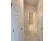 Bright hallway with white trim, multiple white doors, and light-colored wood-look flooring at 13290 Ogden Glade Rd, Dade City, FL 33525
