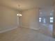 Open living room with tile floors and a view into the kitchen at 13290 Ogden Glade Rd, Dade City, FL 33525