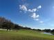Scenic view of the golf course with players putting on the green under a blue sky at 18116 Portside St, Tampa, FL 33647