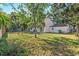 Spacious backyard with a well-maintained lawn and mature trees, offering shade and privacy at 4822 W San Miguel St, Tampa, FL 33629