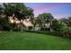 Expansive backyard with a well-maintained lawn, mature trees, and privacy hedge, perfect for outdoor activities at 6020 Kestrel Point Ave, Lithia, FL 33547