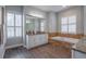 Bathroom offers a tub, granite countertops, dual sinks, and stylish white cabinets at 6020 Kestrel Point Ave, Lithia, FL 33547