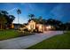 Well-lit home exterior at night featuring a spacious driveway, three-car garage, and lush landscaping at 6020 Kestrel Point Ave, Lithia, FL 33547