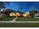 Beautiful home with manicured lawn, professional landscaping, and lighted walkway leading to the front door at 6020 Kestrel Point Ave, Lithia, FL 33547