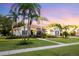 Charming single-story home with a well-manicured lawn, mature palm trees, and a welcoming walkway at 6020 Kestrel Point Ave, Lithia, FL 33547