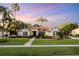 Charming single-story home featuring a lush lawn, mature palm trees, and well-maintained landscaping at 6020 Kestrel Point Ave, Lithia, FL 33547